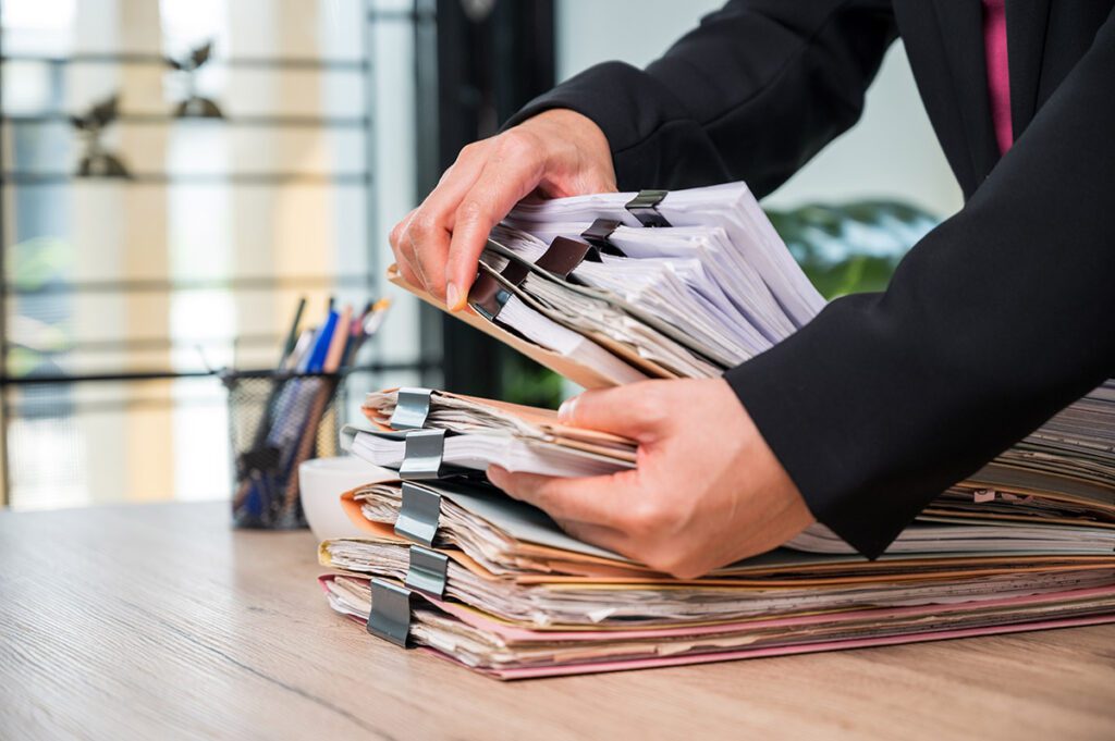 A man laying a stack of documents onto a table.